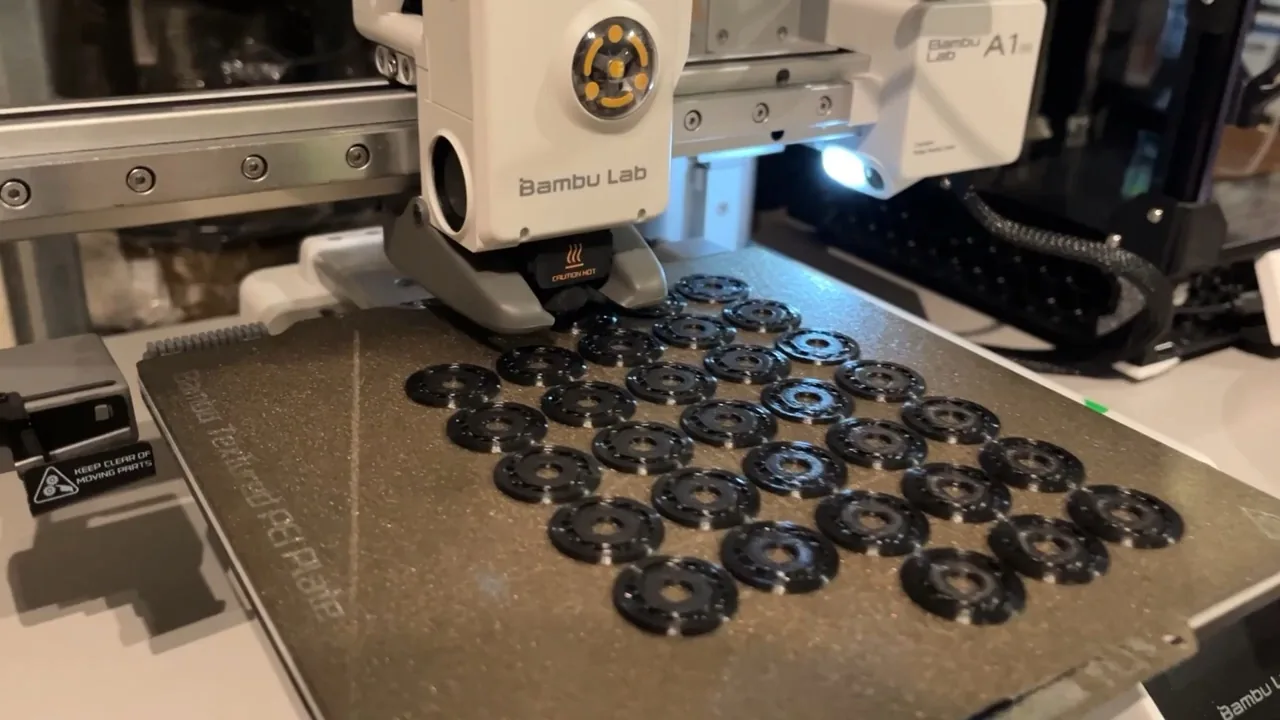 Bambu Lab A1 mini printing a plate of small black parts