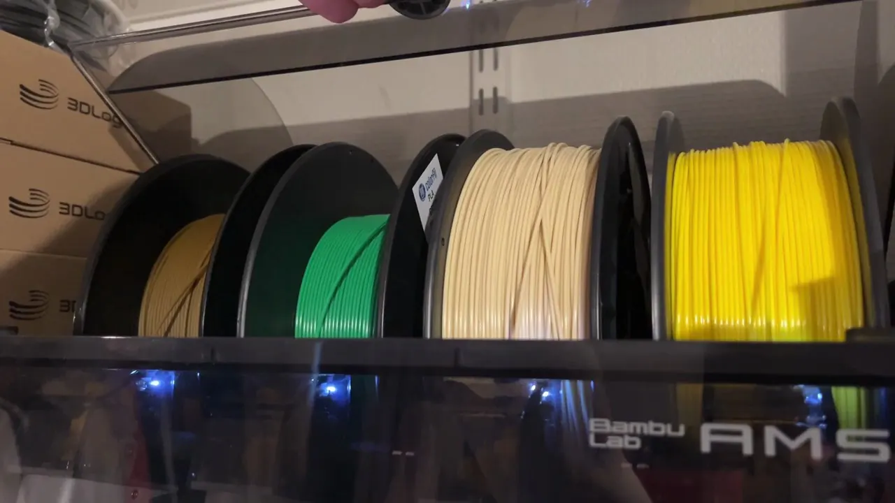 Four filament spools loaded inside a Bambu Lab AMS unit