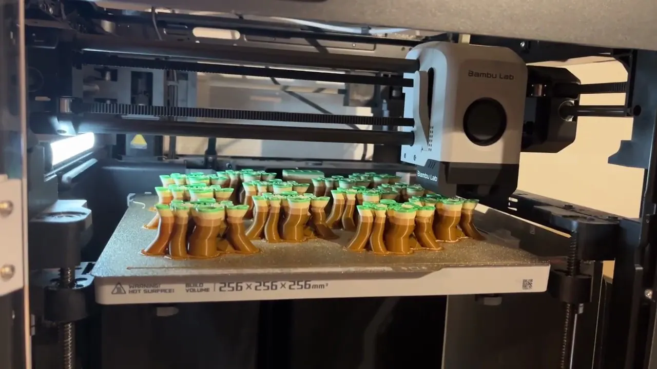 A Bambu Lab P1P printing a multicolour plate of small models