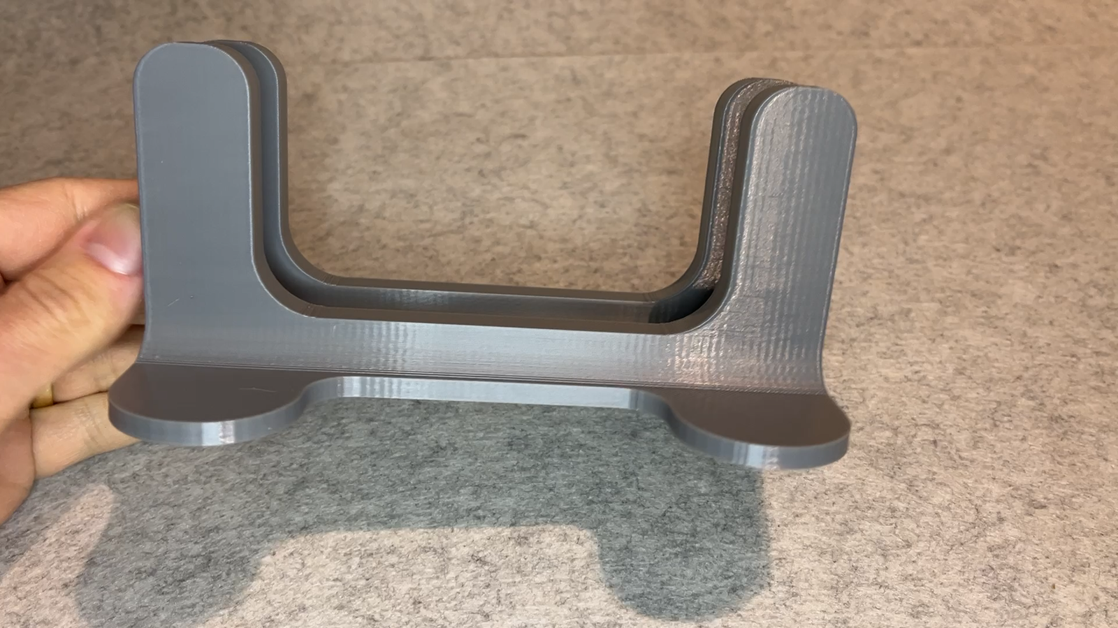 Close-up of a grey 3D printed stand showing smooth surfaces and visible layer lines